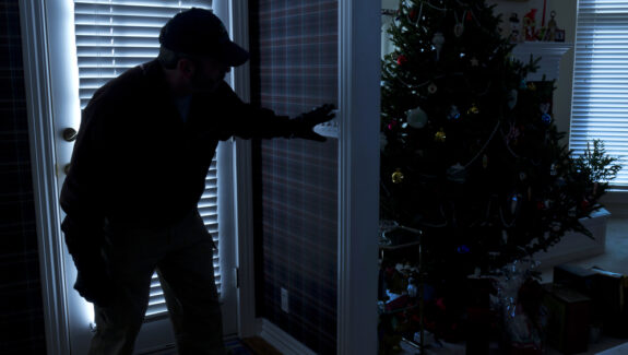An image of a burglar gaining entry to a house at Christmas