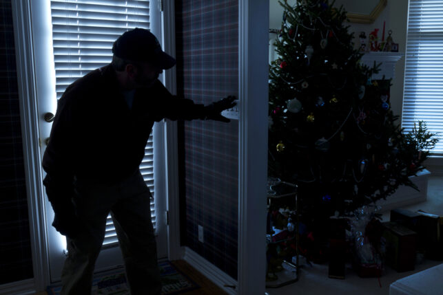 An image of a burglar gaining entry to a house at Christmas