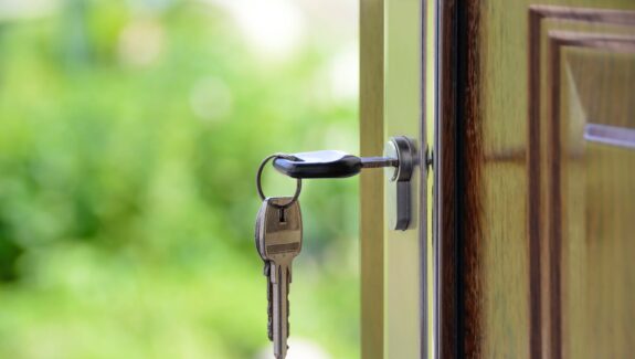 Image of a key in a front door, to emphasise need for better home security when a child is home alone.
